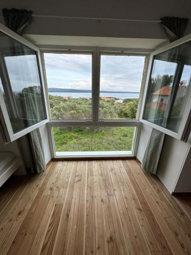 Cette chambre vide dispose de grandes fenêtres et offre une vue sur l'océan. dans l'établissement Matisse Residence, à Nerezine