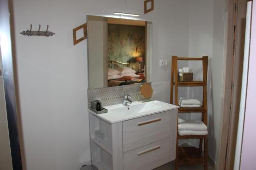 y baño con lavabo y espejo. en Le Clos de la Challangette, en Beaune