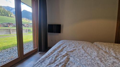 sypialnia z łóżkiem i dużym oknem w obiekcie T3 rez-de-jardin avec fitness, sauna et tennis - village et ski à pied w mieście La Chapelle-dʼAbondance