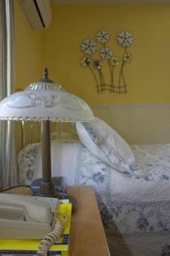 a lamp on a table next to a bed with pillows at Garden South Park Inn in Halifax