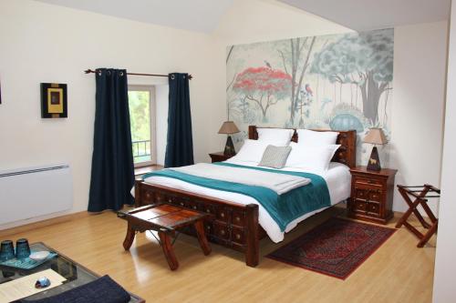 a bedroom with a large bed and a painting on the wall at Le Clos de la Challangette in Beaune