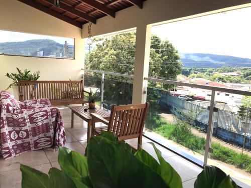 a patio with a table and a chair and a window at Casamatta Hostel - Unidade Aventura in Pirenópolis
