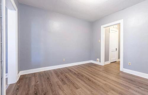 an empty living room with white walls and wood floors at Apartment in Pittsburgh