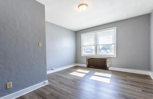 an empty living room with a radiator and a window at Apartment in Pittsburgh