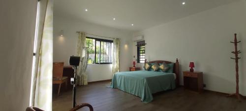 ein Schlafzimmer mit einem Bett und einem TV in der Unterkunft Beautiful House with private pool in Mauritius in Albion