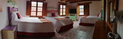 a hotel room with two beds and a television at Hotel Tierra Maya in San Cristóbal de Las Casas