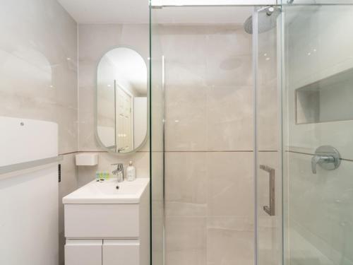 a white bathroom with a shower and a sink at Pass the Keys Spacious Cosy Home Close To London Abbey Wood in London