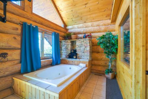 baño con bañera en una cabaña de madera en Smoky Mountain Vacation Rental with Hot Tub! en Gatlinburg