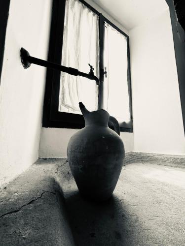 a vase sitting on the floor in front of a window at La Gazza Ladra House in Pieve di Carpegna