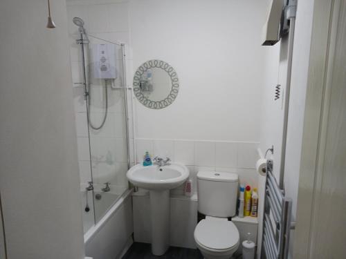 a bathroom with a toilet and a sink and a shower at Cosy 1-Bed Apartment in Swindon private parking in Swindon
