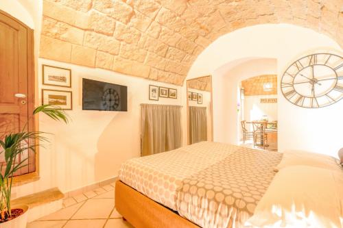1 dormitorio con 1 cama y reloj en la pared en Cozy house in the old city, en Bari