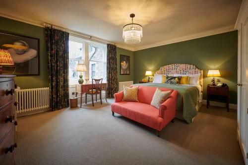 1 dormitorio con 1 cama y 1 silla roja en Cromlix en Kinbuck