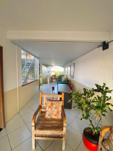 a living room with a bench and a plant at Hostel Da Jô in Ilhéus