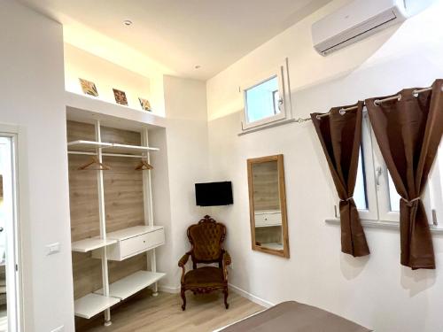 Sikelia Apartment Centro - SELF CHECK-IN في باليرمو: غرفة بها رفوف بيضاء ومرآة وكرسي