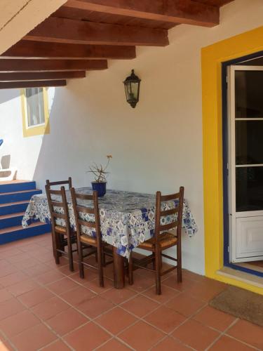 a table and chairs on a patio with a table and a window at Sondela Self Catering in São Martinho do Porto