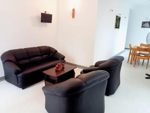 a living room with two leather chairs and a table at Nilwala Gate wetland Stay in Matara