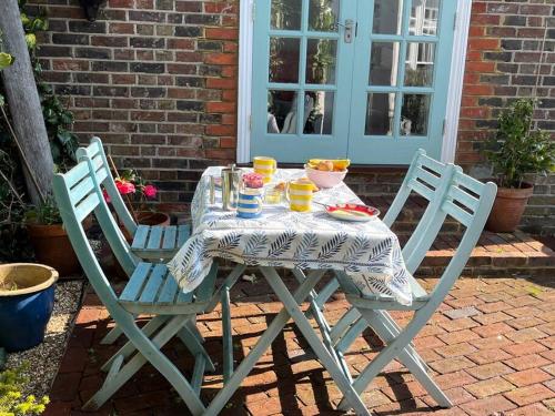 a table with two chairs and a table with drinks on it at Gorgeous Small House in Brighton in Brighton & Hove