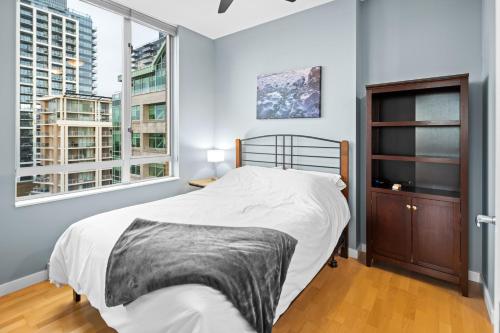 um quarto com uma cama e 2 janelas grandes em Corazon City Suite by Iris Properties! em Victoria