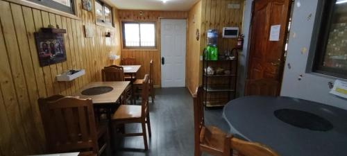 une salle à manger avec des murs en bois, des tables et des chaises dans l'établissement EL ROBLE 2.0 CHILLAN, à Chillán