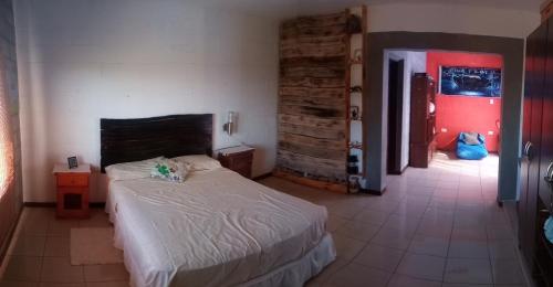sypialnia z łóżkiem i czerwonymi drzwiami w obiekcie Serendipity w mieście San Pedro