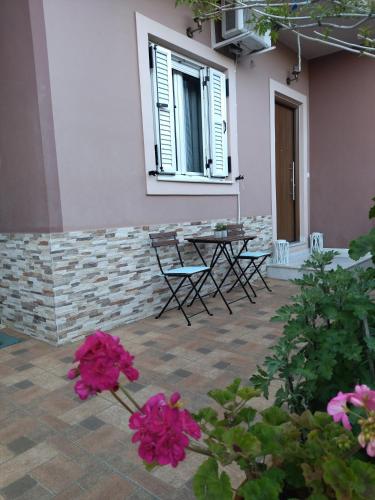 a patio with chairs and a table and flowers at B&B one in Vonitsa
