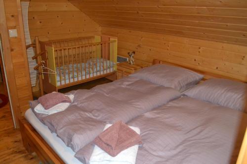 two twin beds in a room with wooden walls at Chata Simon in Nižná Boca