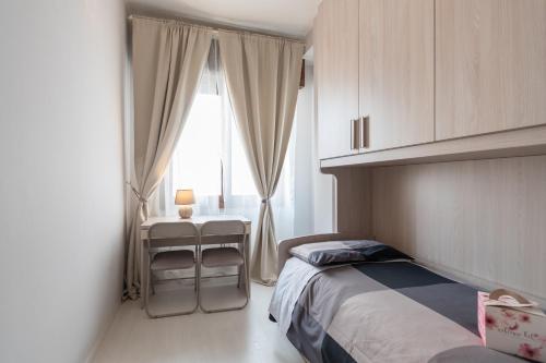 um quarto com uma cama, uma mesa e uma janela em Appartamento Ospedale Civile 5 - F&L Apartment em Brescia