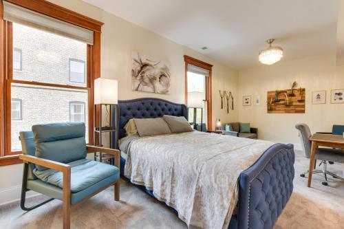 een slaapkamer met een blauw bed en een stoel bij Chic Chicago Apartment about 1 Mi to Wrigley Field! in Chicago