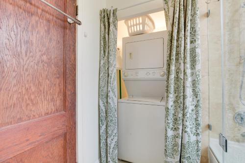 een badkamer met een wasmachine en droger en een deur bij Chic Chicago Apartment about 1 Mi to Wrigley Field! in Chicago