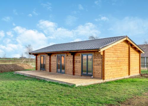 a small wooden cabin with a deck in a field at Beautiful Home In Nafferton With Wifi in Nafferton