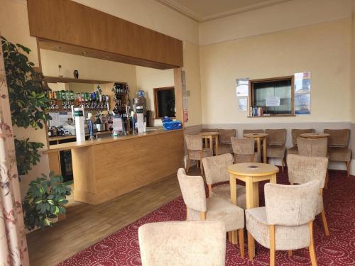 a waiting room with chairs and a bar at Cavendish Hotel in Exmouth