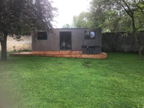 a small house in a yard with a grass field at Hôtel Le Saint Martin in Sablé-sur-Sarthe