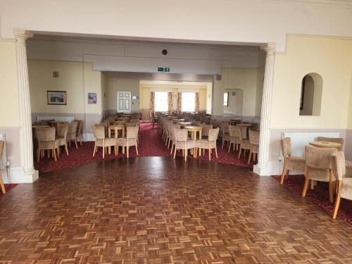 uma sala de jantar vazia com mesas e cadeiras em Cavendish Hotel em Exmouth