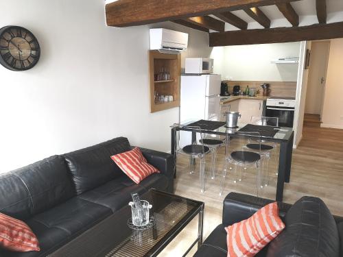 een woonkamer met een zwarte bank en een keuken bij Au Terminus 6 Personnes in Hautvillers