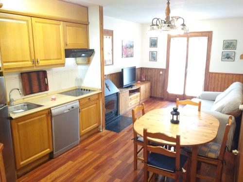 a kitchen with a wooden table and a kitchen with a dining room at Apartamento con terraza y vistas panorámicas en Taüll in Taull