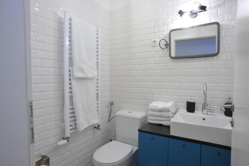 a white bathroom with a toilet and a mirror at Apartment Calliope in Zagreb