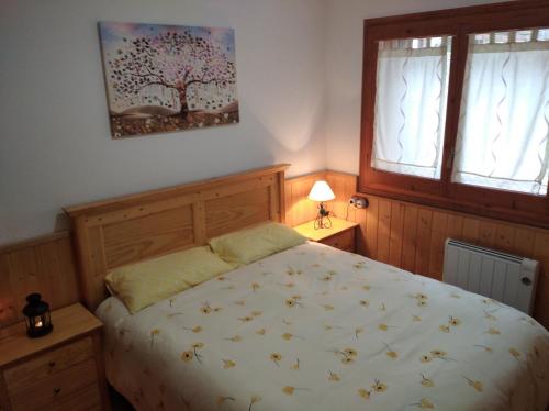 1 dormitorio con 1 cama y una pintura de árbol en la pared en Apartamento con terraza y vistas panorámicas en Taüll, en Taüll