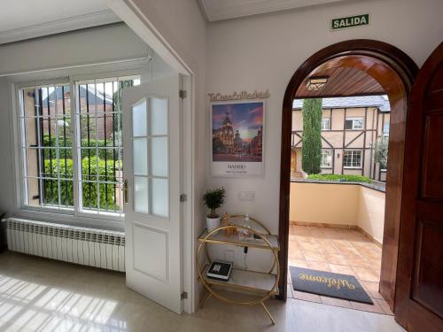 Moderna Casa de Lujo con Jardín y Barbacoa في مدريد: باب مفتوح لغرفة مع شرفة