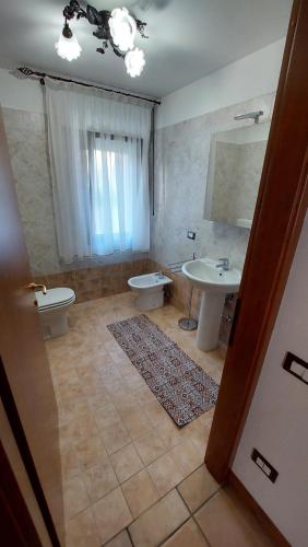 a bathroom with a sink and a toilet and a mirror at Villa Augusta in Auronzo di Cadore