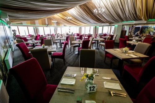 a dining room with tables and red chairs at Kings Croft Hotel in Pontefract