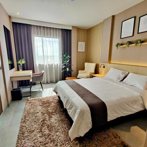 a hotel room with a large bed and a desk at The Mango Suites by Flat06 in Jakarta