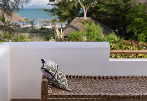 two pillows sitting on a bench near the beach at Beba.Beach.House in Watamu