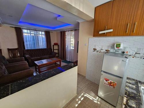 uma cozinha com um frigorífico e uma sala de estar em The Barn Entire 3 Bed House Self catering em Ruaka