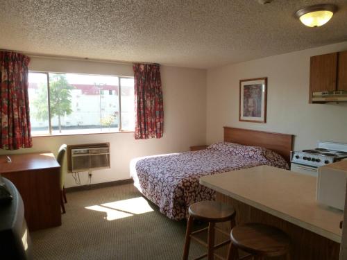mały pokój hotelowy z łóżkiem i kuchnią w obiekcie Sunshine Motel II w mieście Fife