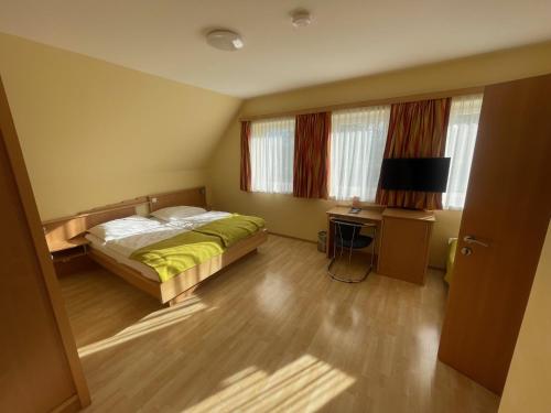 a bedroom with a bed and a table and windows at Hotel Highway - Bed & Breakfast in Lieboch