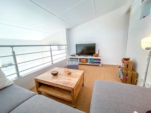 a living room with a couch and a coffee table at L'Odyssée provençale, un duplex de charme de 2 chambres au pied du village médiéval de Bormes-les-Mimosas, offrant des prestations haut de gamme et une superbe vue sur le Massif des Maures in Bormes-les-Mimosas