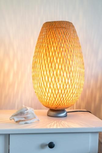 a yellow lamp sitting on top of a table at L'Odyssée provençale, un duplex de charme de 2 chambres au pied du village médiéval de Bormes-les-Mimosas, offrant des prestations haut de gamme et une superbe vue sur le Massif des Maures in Bormes-les-Mimosas