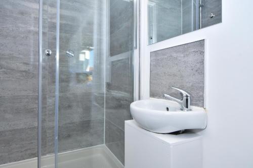 uma casa de banho com um lavatório e um chuveiro em Find a touch of inspiration in this professional interior designers home! em Crewe