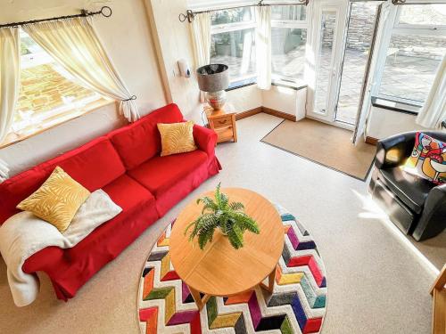 a living room with a red couch and a table at Tramways in Carnbrea