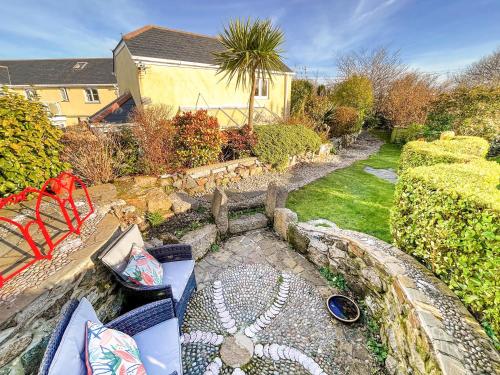a garden with a bench and a yard with a house at Tramways in Carnbrea